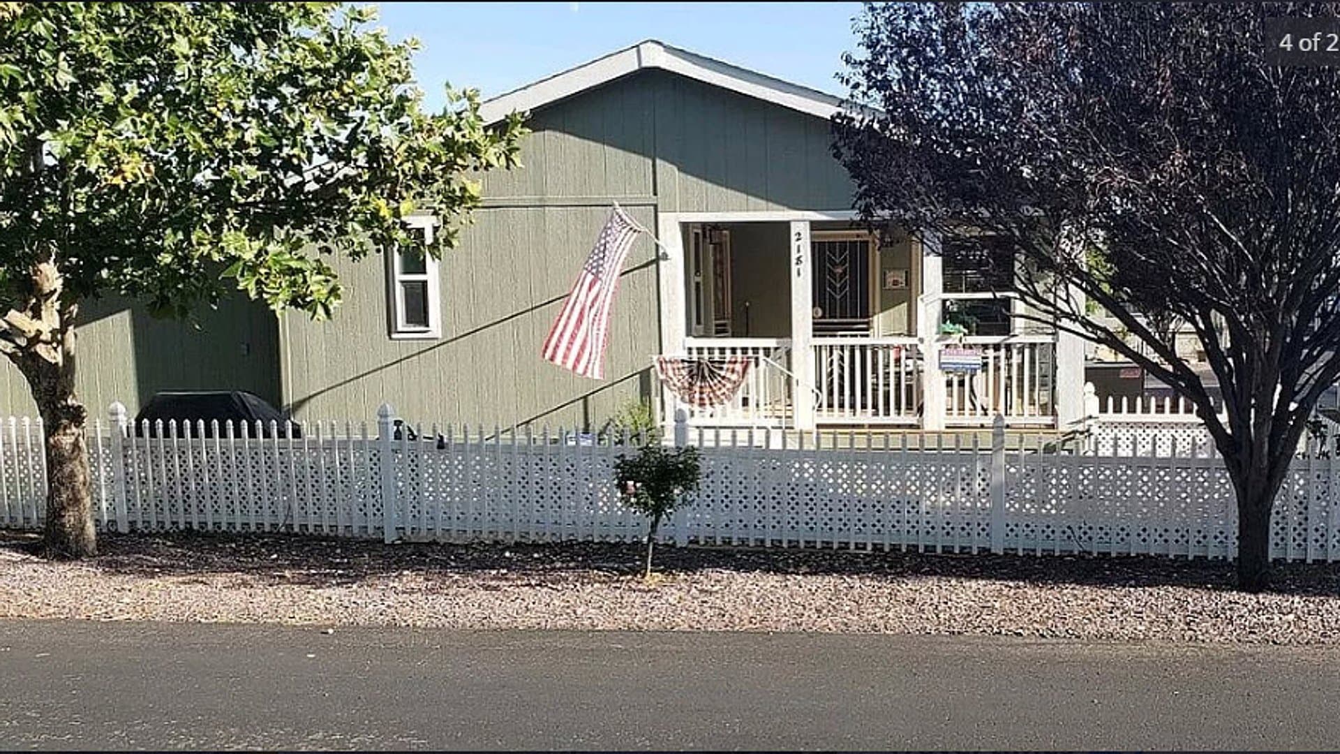 A move-in-ready home for sale at Orchard Ranch RV Resort behind a white picket fence.